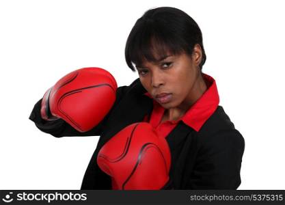 Female office worker wearing boxing gloves