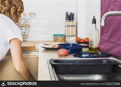 female opening cupboard sink