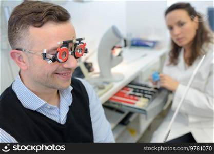 female optometrist examining smiling patient