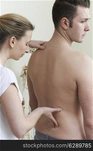Female Osteopath Trating Male Patient With Back Problem