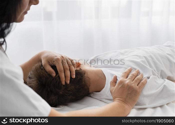 female osteopathist treating boy by massaging him. Beautiful photo. female osteopathist treating boy by massaging him