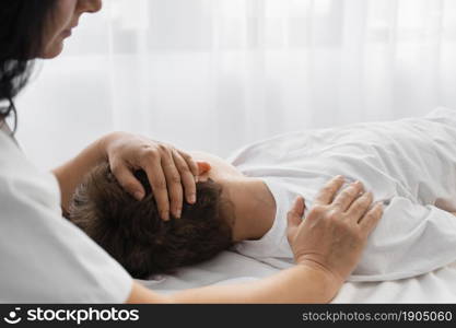 female osteopathist treating boy by massaging him. Beautiful photo. female osteopathist treating boy by massaging him