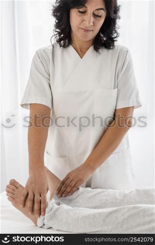female osteopathist treating patient s legs hospital