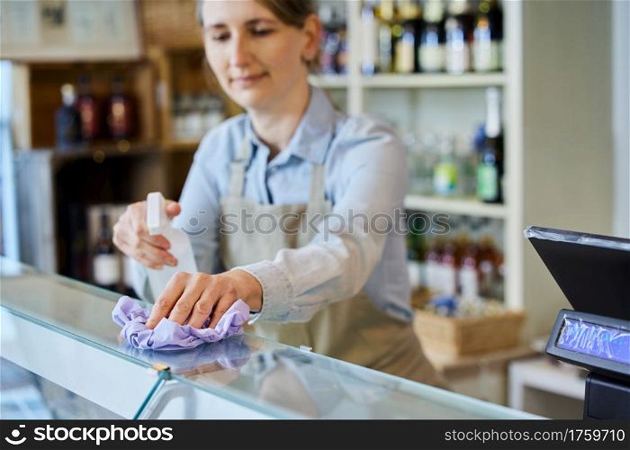 Female Owner Delicatessen Cleaning Counter With Sanitising Spray