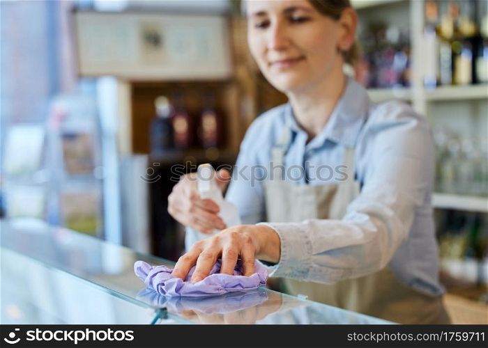 Female Owner Delicatessen Cleaning Counter With Sanitising Spray