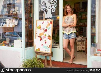 Female Owner Of Delicatessen Standing Outside Shop