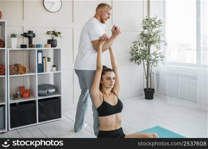 female patient doing exercises physiotherapy with male physiotherapist