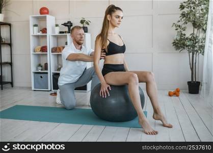 female patient doing exercises with ball physiotherapist