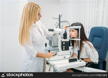 Female patient on diagnostic of vision, professional choice of glasses lens. Eyesight test in oculist cabinet. Consultation in optician office, ophthalmology. Patient on diagnostic of vision, oculist cabinet