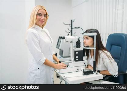 Female patient on diagnostic of vision, professional choice of glasses lens. Eyesight test in oculist cabinet. Consultation in optician office, ophthalmology. Patient on diagnostic of vision, oculist cabinet