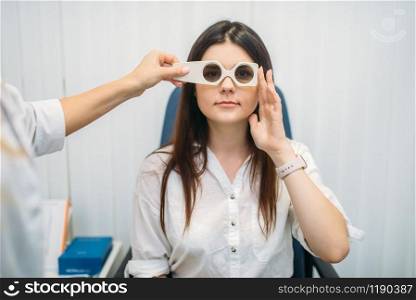 Female patient on diagnostic of vision, professional choice of glasses lens. Eyesight test in optician cabinet. Consultation with oculist, ophthalmology. Patient on diagnostic of vision, optician cabinet