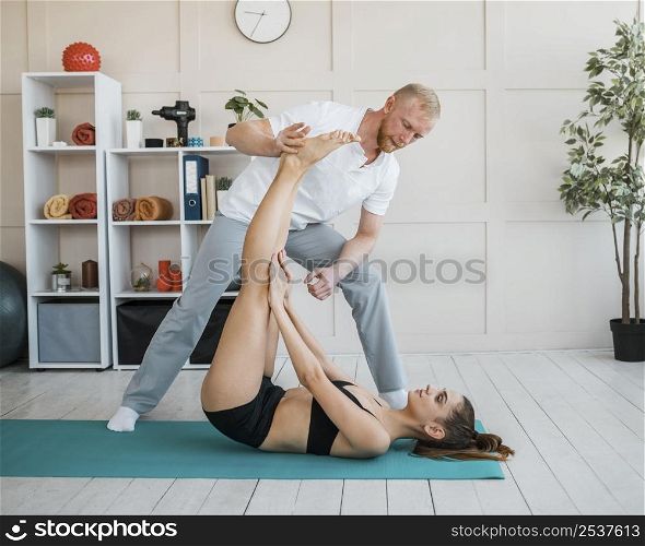 female patient physiotherapy doing exercises with male physiotherapist
