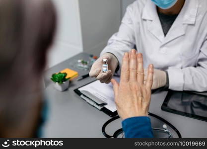 Female patient refusing the coronavirus vaccine offered by her doctor