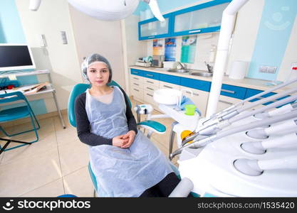 Female patient waiting for dental treatment in a dental chair. Dental Hygiene and Health conceptual image.