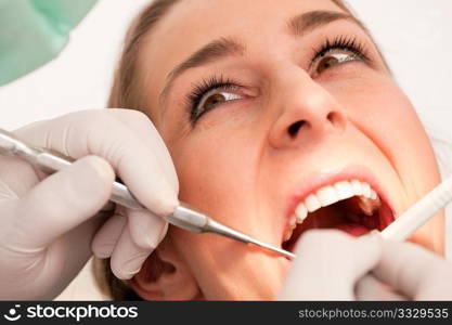 Female patient with dentist in the course of a dental treatment, FOCUS ON EYES