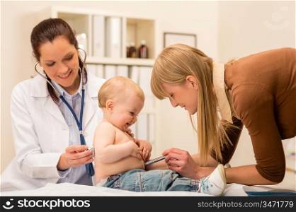 Female pediatrician checking cute baby girl with stethoscope mother assistance