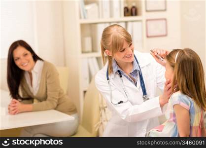 Female pediatrician doing eye check-up to little girl