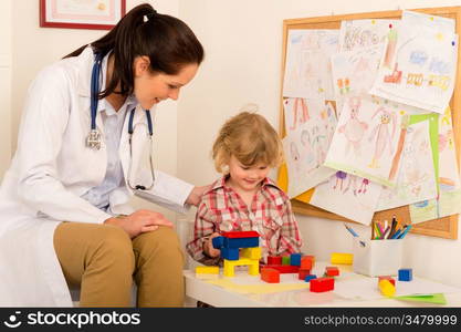 Female pediatrician playing with little girl at medical office