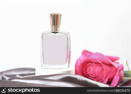 female perfume bottle on a grey silk background with pink fresh rose bud. gift for a woman, fragrances for women, perfumery shop. female perfume bottle on a grey silk background with pink fresh rose bud. gift for a woman, fragrances for women, perfumery shop.