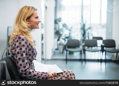 Female person at the interview in business office. Secretary or manager conducts negotiations sitting on a chair. Job search or head hunting concept