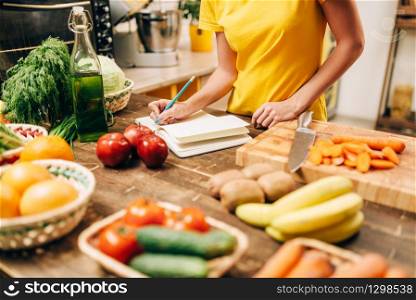 Female person cooking on the kitchen, healthy bio food. Vegetarian diet, fresh vegetables and fruits on wooden table