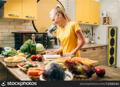 Female person cooking on the kitchen, healthy organic food. Vegetarian diet, fresh vegetables and fruits on wooden table. Female person cooking on the kitchen, organic food
