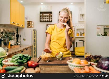 Female person cooking on the kitchen, healthy organic food preparing. Vegetarian diet, fresh vegetables and fruits on wooden table. Female person cooking, organic food preparing