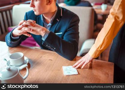 Female person hands gives to man a love note with a phone number closeup view. Attractive proposal