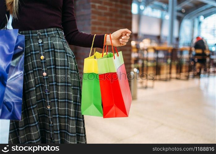 Female person with shopping bags in mall. Shopaholic in clothing store, consumerism lifestyle, fashion, woman purchasing in shop