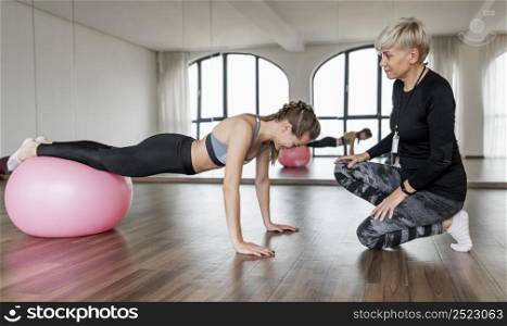 female personal trainer client using fitness ball