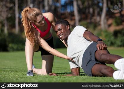 female personal trainer guides sportsman in side plank position