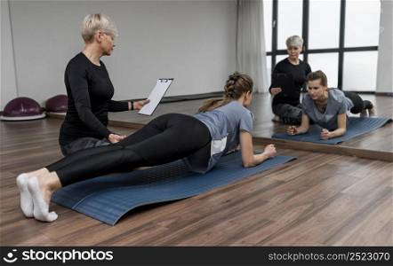 female personal trainer her client doing plank