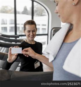 female personal trainer her client holding card