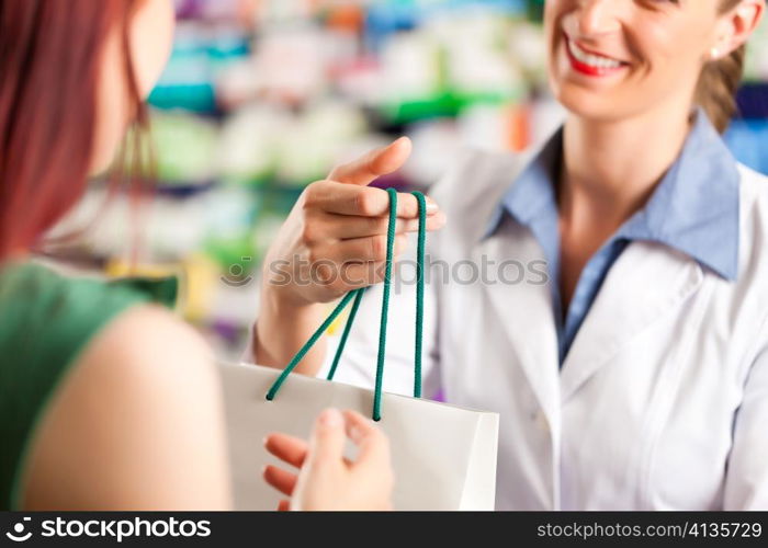 Female pharmacist with a female customer in her pharmacy