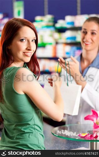 Female pharmacist with a female customer in her pharmacy