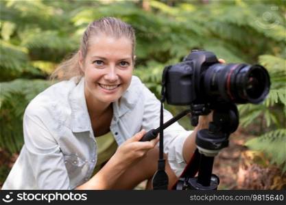 female photographer crouching among ferns