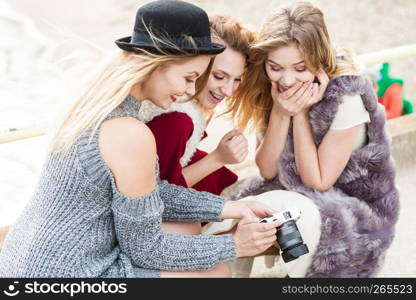 Female photographer showing fashion models results of photo shoot. Behind the scenes of professional modeling and photography industry.. Photographer showing fashion models photos
