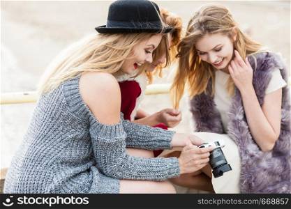 Female photographer showing fashion models results of photo shoot. Behind the scenes of professional modeling and photography industry.. Photographer showing fashion models photos