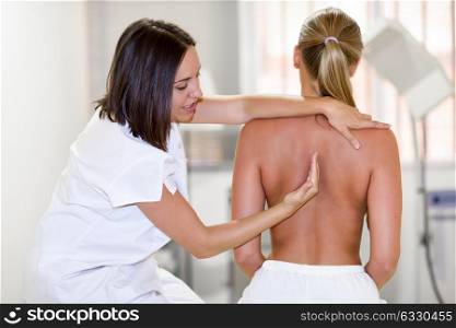 female physiotherapist inspecting her patient. Medical check at the shoulder in a physiotherapy center.