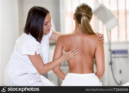 female physiotherapist inspecting her patient. Medical check at the shoulder in a physiotherapy center.