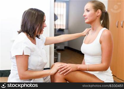 Female physiotherapist inspecting her patient. Medical check to a blonde girl in a physiotherapy center.