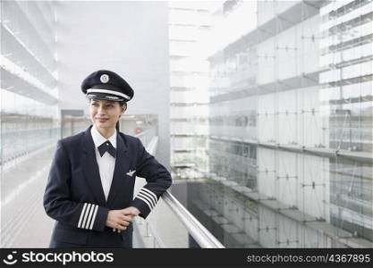 Female pilot leaning against a railing
