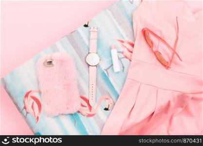 Female pink dress, mobile phone in pink case, watch with pink stripe on pink background
