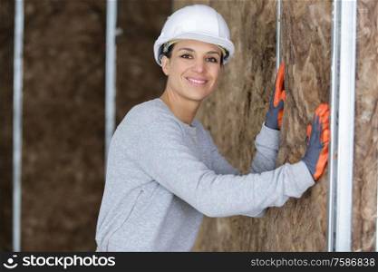 female plasterer worker at a indoors wall insulation works
