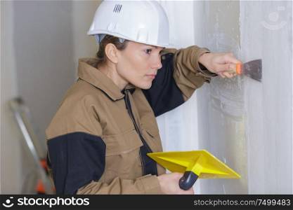 female plasterer working on interior wall