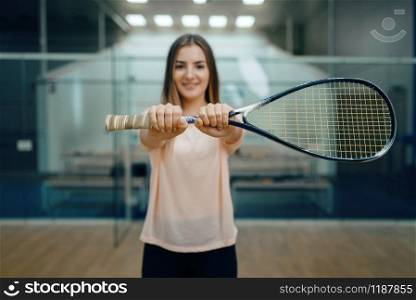 Female player shows squash racket on court. Girl on game training, active sport hobby, fit workout for healthy lifestyle. Female player shows squash racket on court