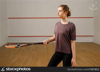 Female player with squash racket and ball on court. Girl on game training, active sport hobby, fit workout for healthy lifestyle. Female player with squash racket and ball on court