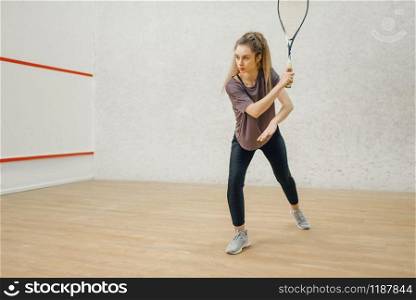 Female player with squash racket in action. Girl on game training, active sport hobby on court. Female player with squash racket in action