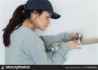 female plumber fixing toilet flush
