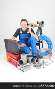 Female plumber knelt down by equipment